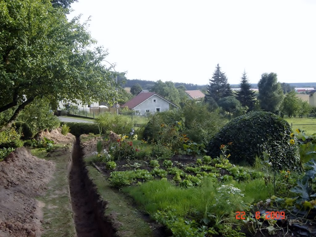 Leitungsgraben für die Fernwärme zwischen Gärten